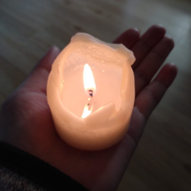 eine Hand hält eine Kerze